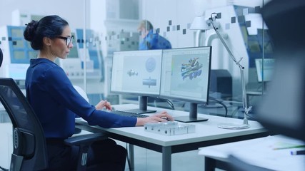 Poster - Female Industrial Engineer Solving Problems, Working on a Personal Computer, Two Monitor Screens Show CAD Software with 3D Prototype of Engine Being Tested. Working Modern Factory