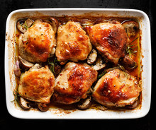 Roasted Chicken Thighs With Mushrooms, Garlic And Herbs In A Baking Dish, Top View