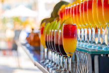 Row Of Glasses With Natural Juice On The Bar Near The Pool. Summer Luxury Tropical Restaurant. Elegant Cocktails Set With Fruits.
