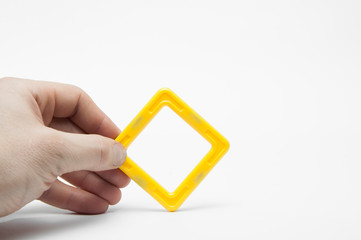 Geometric shape rhombus, square. In the hand. On white background