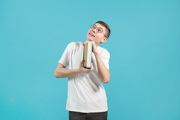 Wall Mural - nerd holding books in his hands and smiling looking up