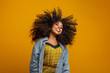 © Brastock Images - Beauty portrait of african american woman with afro hairstyle and glamour makeup. Brazilian woman. Mixed race. Curly hair. Hair style. Yellow background.