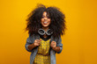 © Brastock Images - Female student in campus with books in her arms. Yellow background.