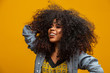 © Brastock Images - Beauty portrait of african american woman with afro hairstyle and glamour makeup. Brazilian woman. Mixed race. Curly hair. Hair style. Yellow background.