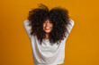Beauty portrait of african american woman with afro hairstyle and glamour makeup. Brazilian woman. Mixed race. Curly hair. Hair style. Yellow background.