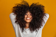 © Brastock Images - Beauty portrait of african american woman with afro hairstyle and glamour makeup. Brazilian woman. Mixed race. Curly hair. Hair style. Yellow background.