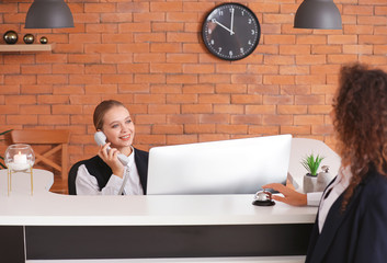 Sticker - Young female receptionist working with guest in hotel