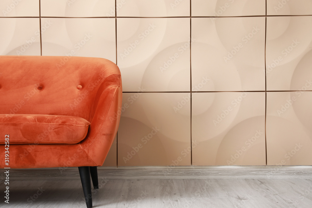 Stylish sofa near light wall in room
