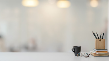 Wall Mural - Close up view of workspace with stationery, glasses and coffee cup on white table with blurred background