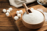 Fototapeta  - Granulated sugar in bowl on wooden table