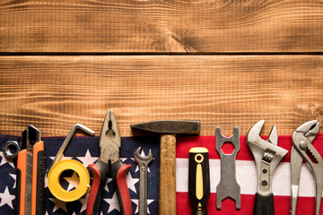 Wall Mural - Labor day. American flag and various tools on a wooden background. The concept of labor day. Empty space for text.