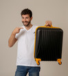 © SB Arts Media - Stylish handsome man showing suitcase. Advertising storage space for travelers and tourism image.