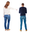 © ghoststone - Back view of couple couple in sweater pointing.