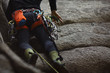 © esalienko - Climbing equipment on the harness of the climber on the background of a technical terrain, close-up.