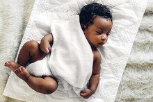 Portrait Of Cute Adorable Little African American Baby Sleep In A White Bedroom