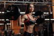 © Screaghin - Sporty young woman exercising with barbell in gym. Sport, fitness, powerlifting and people concept.