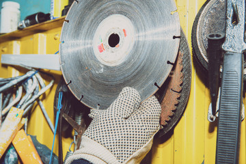 Poster - A set of tools on a yellow wall. Concept of work in a home workshop, doing homework. Tools such as the grinding wheel, saw hang on the wall.