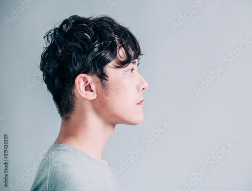 Cuadros en Lienzo side view of young smiling handsome man isolated on gray background