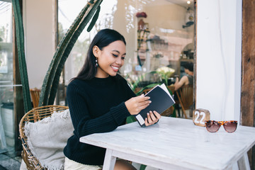 Young Asian female with notebook on table