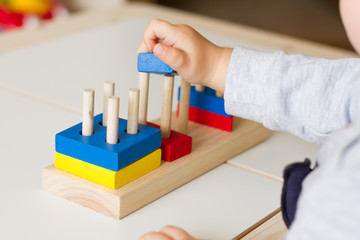 Toy made of wood for the study of shapes and colors. Useful game for a child on a white table. Montessori Education. Materials for the school. Materials on geometry. the concept of teaching children.