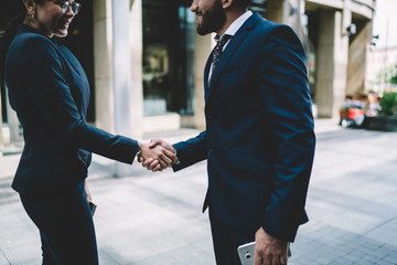 Content colleagues shaking hands in city