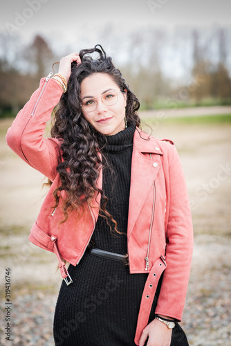 Fotografía belle jeune femme brune au cheveux longs avec lunette et veste en cuir rose