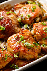 Wall Mural - Roasted chicken thighs with mushrooms, garlic and herbs in a baking dish, close-up