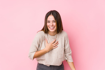 Wall Mural - Young caucasian woman posing isolated laughs happily and has fun keeping hands on stomach.