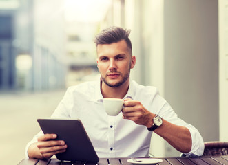 Wall Mural - business, technology and people concept - young man with tablet pc computer and coffee cup at city street cafe