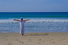 Senior Woman With Gray Hair Doing Qi Gong And Yoga On The Beach Of Tarifa