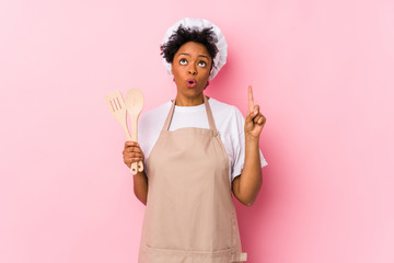 Wall Mural - Young african american cook woman having some great idea, concept of creativity.