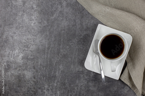 Obraz Dibond Breakfast with black coffee. On a gray concrete background, in a white bowl and with a beige napkin. Top view. Copy space.