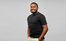 People Concept - Happy Smiling Young African American Man In Black T-shirt Over Grey Background