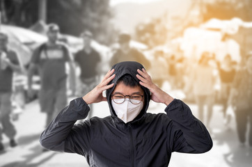 Asian man wearing surgical mask to prevent flu disease Corona virus and PM 2.5 dust with blurred image of crowded