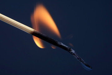 burning and Smoking wooden match on dark background