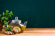 © Fattyplace - Fresh mint herbal tea in glass teapot, front view background