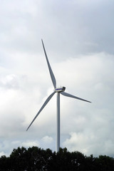 Wall Mural - Wind stations. Windmills for electricity production. Wind turbines generating electricity against a cloudy blue sky. Energy saving concept.