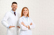 © Pixel-Shot - Team of doctors on white brick background