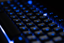 Letters On A Blue Illuminated Blue Keyboard In Dark Close Up