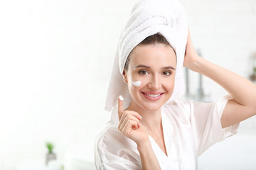 Wall Mural - Beautiful young woman applying cream at home