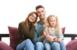 © Pixel-Shot - Happy young family sitting on sofa against white background