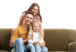 © Pixel-Shot - Happy young family sitting with sofa on white background