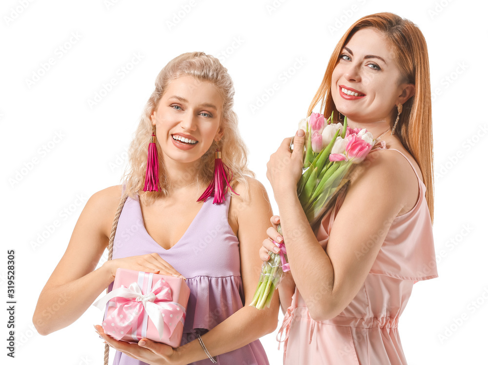 Beautiful young women with gifts on white background. International Women's Day celebration