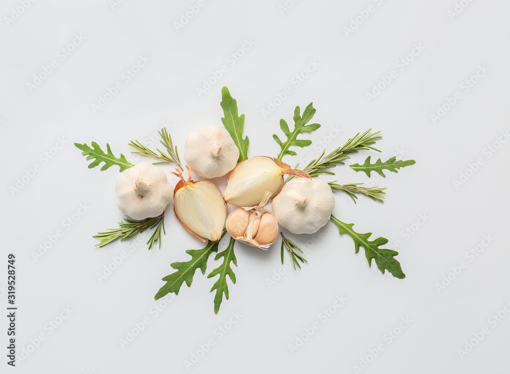 Fresh garlic and arugula on white background