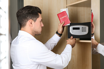 Man opening black steel safe with electronic lock at hotel