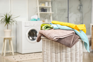 Canvas Print - Wicker basket with laundry and washing machine in bathroom. Space for text