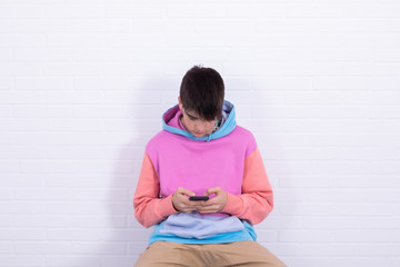 Canvas Print - young teenage boy or student with mobile phone sitting on the chair