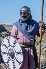 Portrait of a Viking warrior with helmet and armed with spear, shield and sword