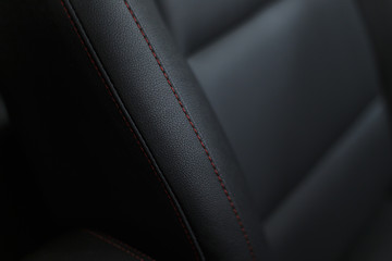 Wall Mural - Part of stitched leather black leather car interior. Modern luxury car black perforated leather interior. Car leather interior details. Decorative seam