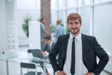 Wall Mural - close up. smiling businessman standing in his office.